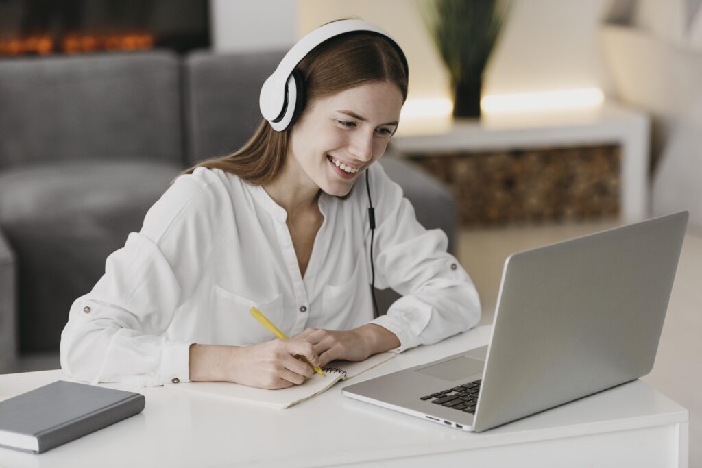 Studentka ze słuchawkami na uszach, ucząca się online